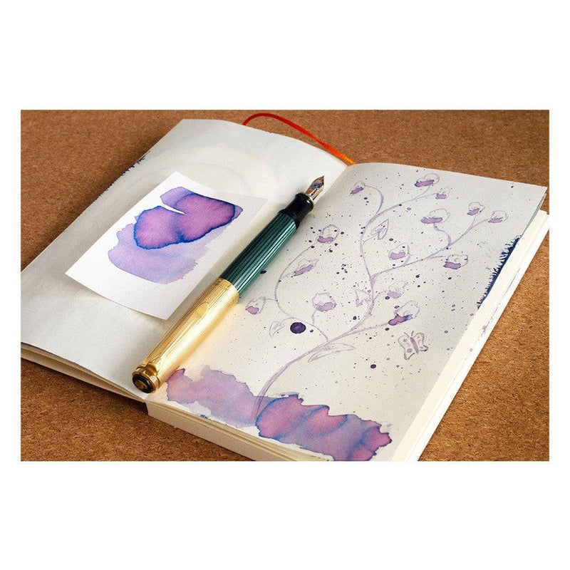 Pennonia Orgona Lilac Ink Bottle (60ml) - A Fountain Pen On Top Of A Notebook With An Ink Drawing