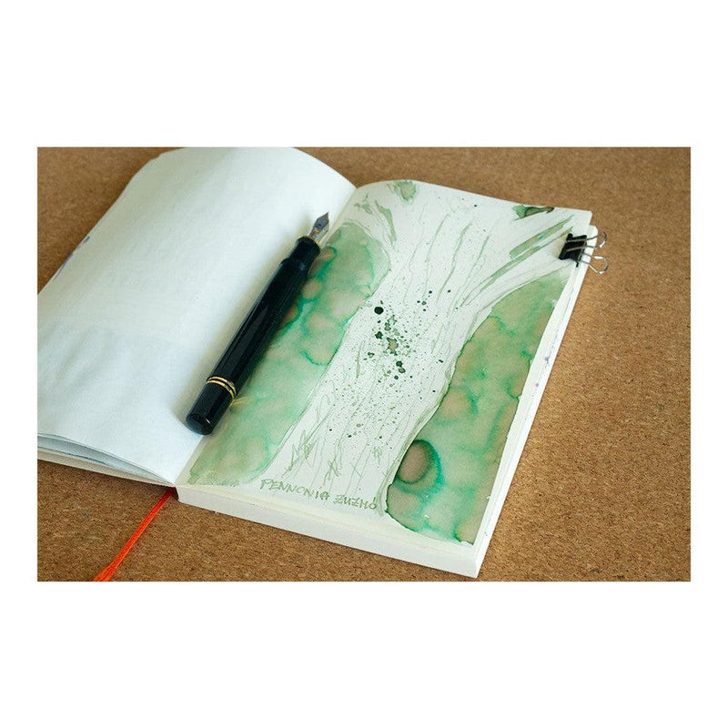 Pennonia Zuzmó Lichen Ink Bottle (60ml) - A Fountain Pen On Top Of A Notebook With An Ink Drawing