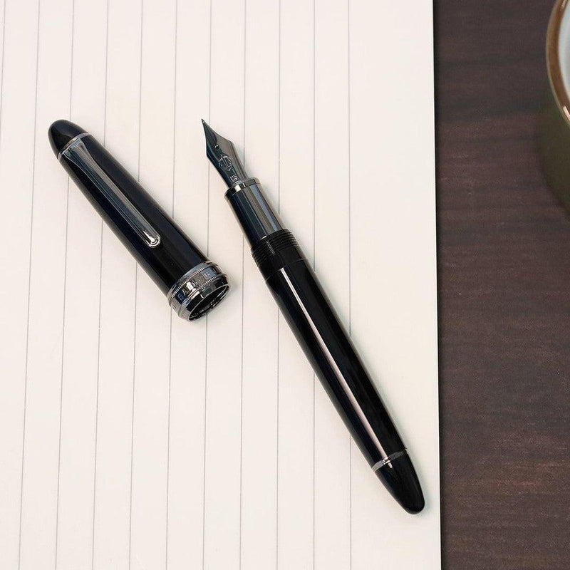 Sailor Naginata Togi Black Trim Fountain Pen - Pen With Cap Removed On Top Of Notebook | EndlessPens