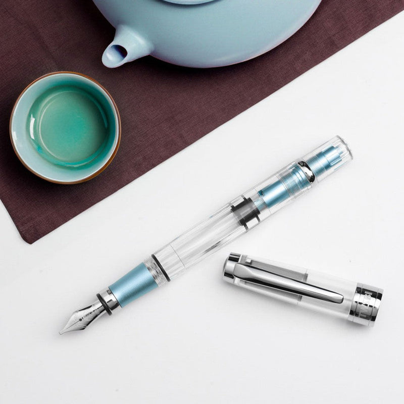 TWSBI Diamond 580AL Iceberg Fountain Pen - Pen With Detached Cap Cover With A Cup and A Jar On Background | EndlessPens