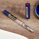 TWSBI ECO Dark Sapphire Fountain Pen - Pen With Detached Cap Cover And Notebook On Top Of Table | EndlessPens