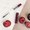 TWSBI ECO Plum with Onyx Fountain Pen - Pen and Cap Cover with Plums on Table | EndlessPens